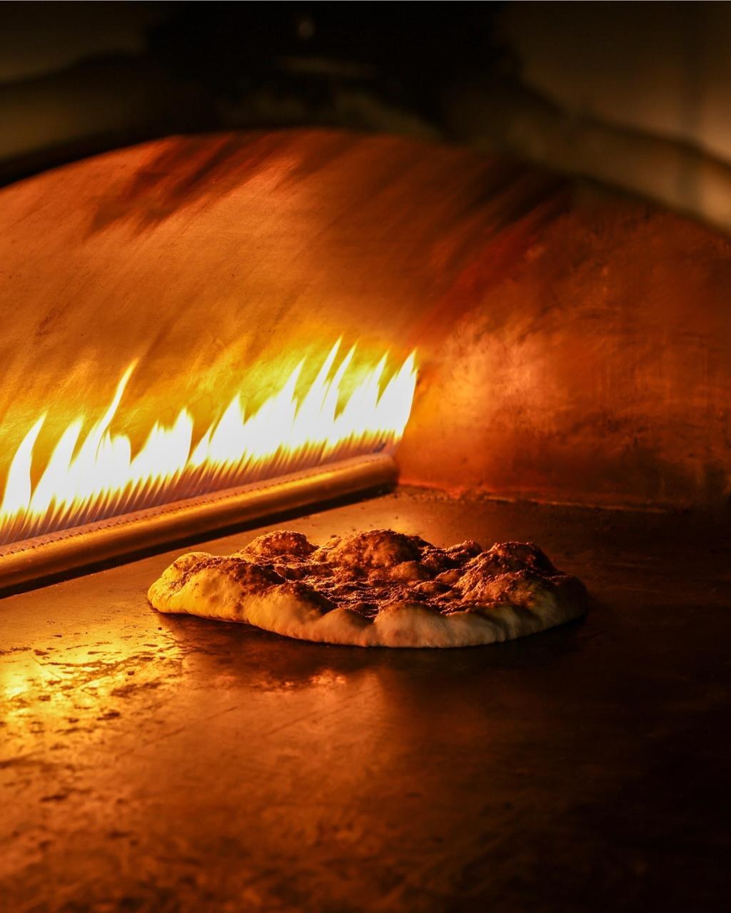 Fresh dough baking beside the flame in the Arax bakery oven in Larnaca