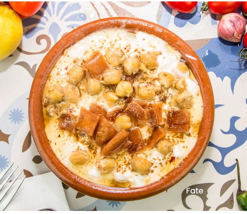 Fate with chickpeas, yogurt and toasted bread served in a clay bowl